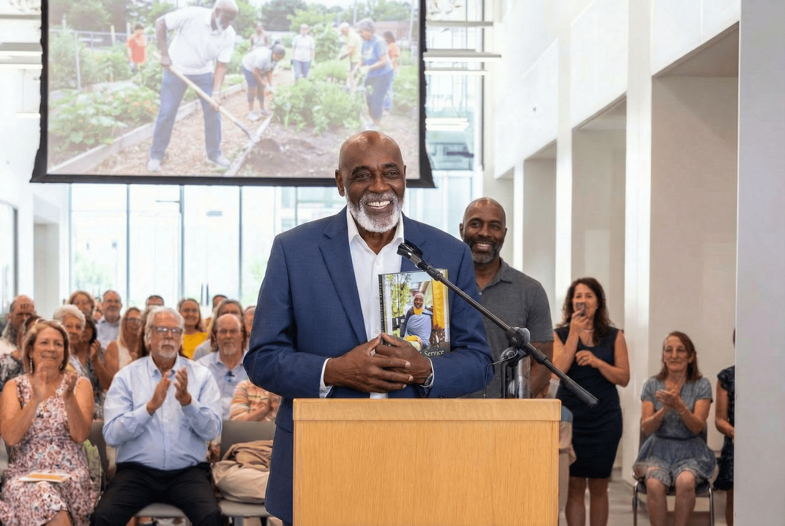 Community leader receiving life story book at recognition ceremony